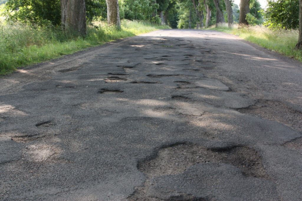 Road full of potholes. Tallai Driveways can fix this